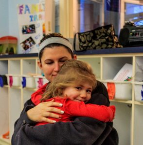 a teacher at The Learning Center holding a child